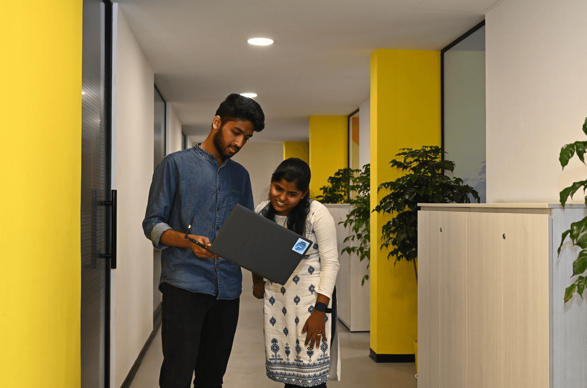 Team collaborating around a laptop at Virya